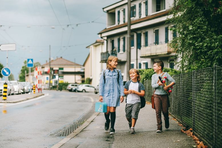 Drei Kinder unterwegs auf dem Trottoir