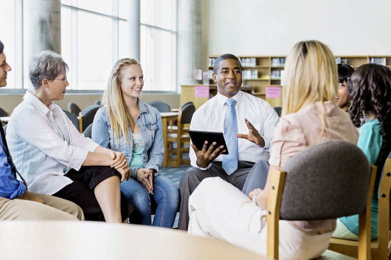 482785397 Man leading discussion group of adults and teens