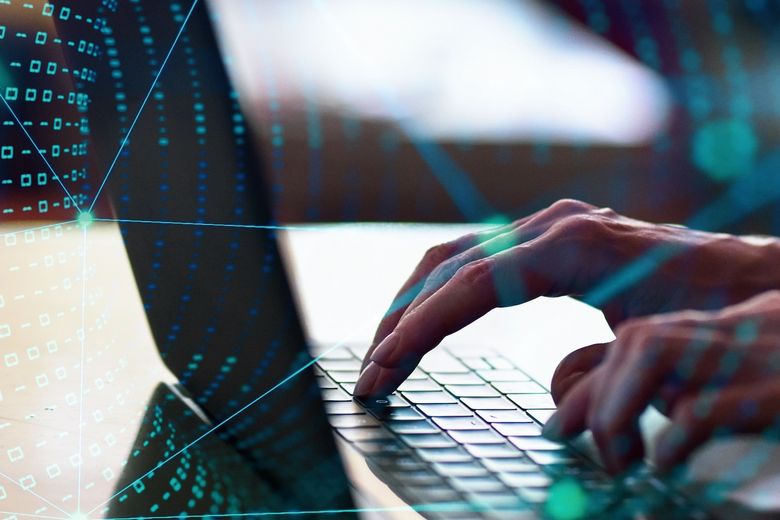 Woman's hand using laptop computer with technological backgrounds Hände tippen auf einem Laptop umgeben von einem virtuellen Netzwerk.
