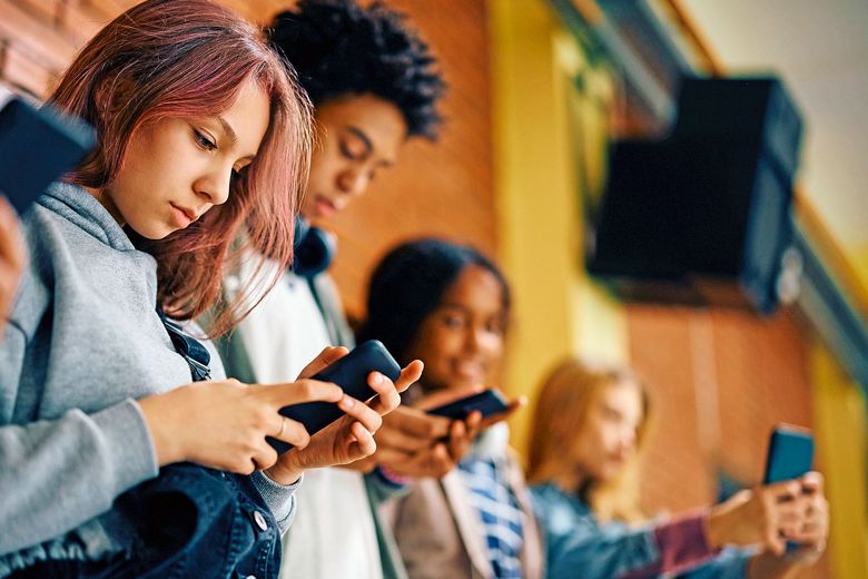 1500076836 Schüerinnen und Schüler schauen auf ihr Handy.