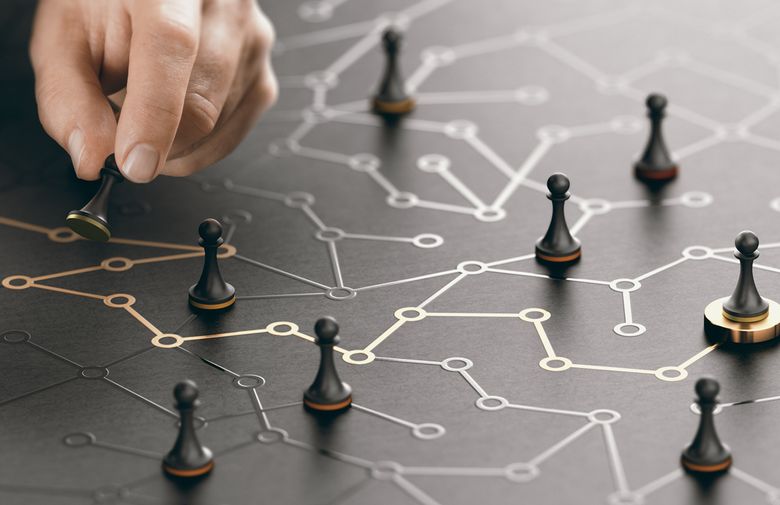 The Way To Success Or Career Guidance. Eine Hand setzt Spielfiguren auf ein virtuelles Netz.