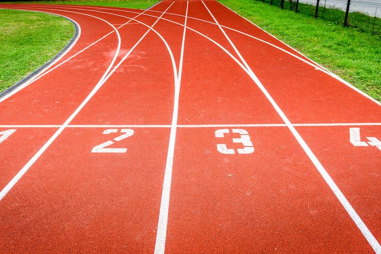 Start numbers on athletic running track in stadium. Leichtathletik-Laufbahnen mit einer Abzweigung