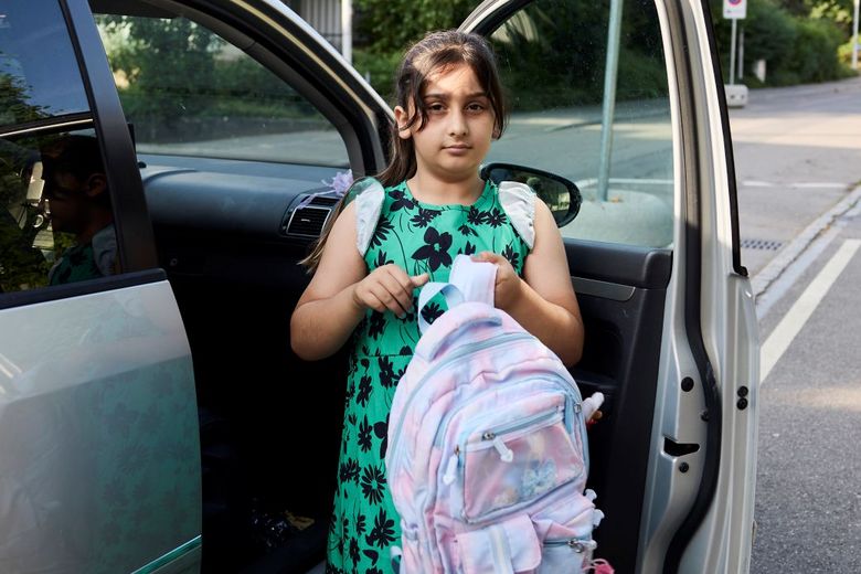 Mädchen mit Rucksack steigt aus einem Auto aus