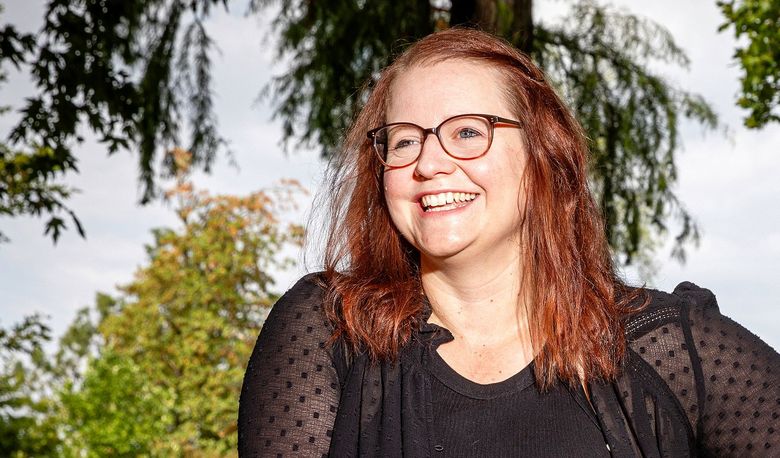 Eine lachende Frau im Grünen.